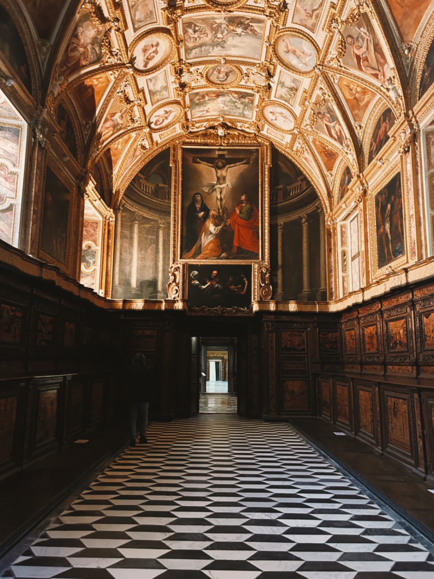 church corridor with a checkerboard floor and paintings