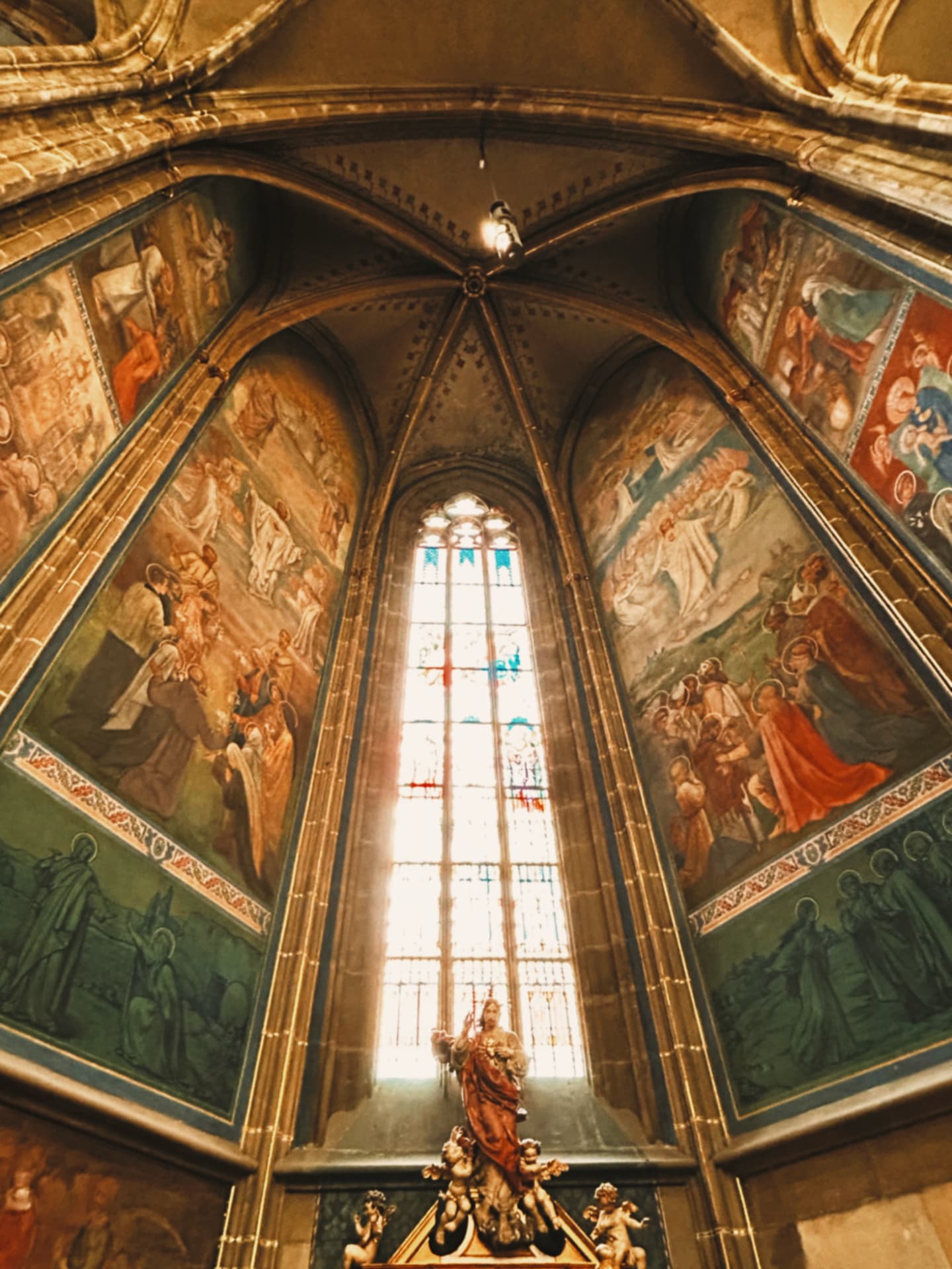 painted apse walls around a stained-glass window