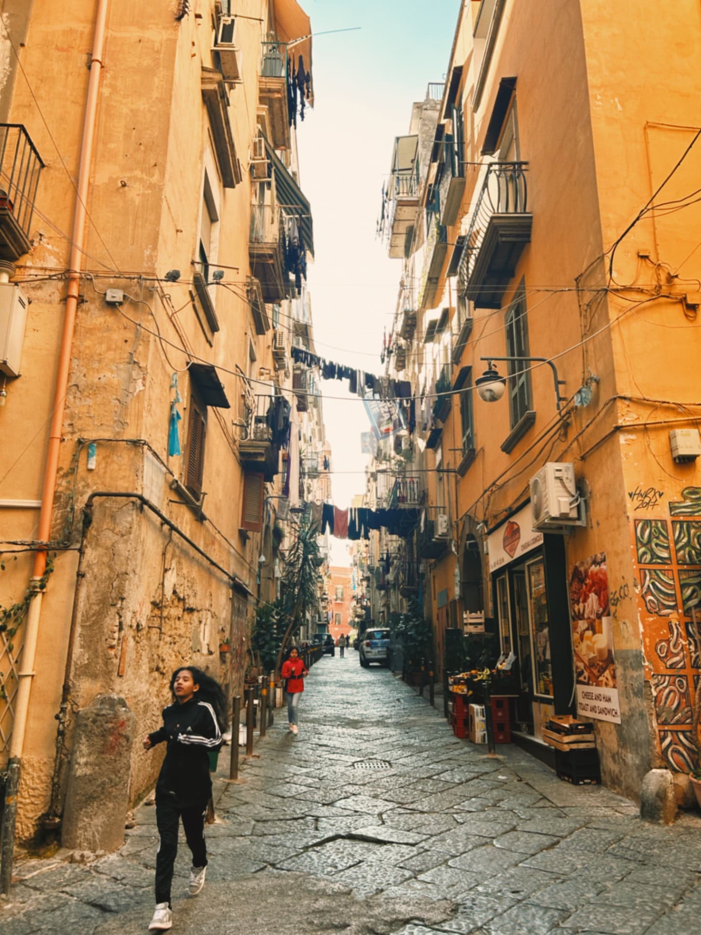 a narrow alley between ochre apartment buildings