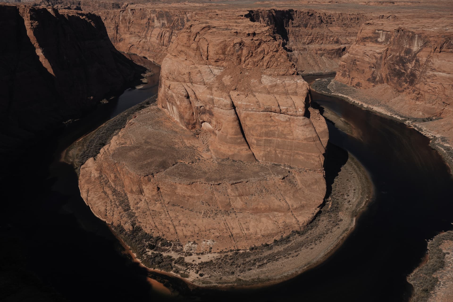 A horseshoe bend of a river through red rock cliffs