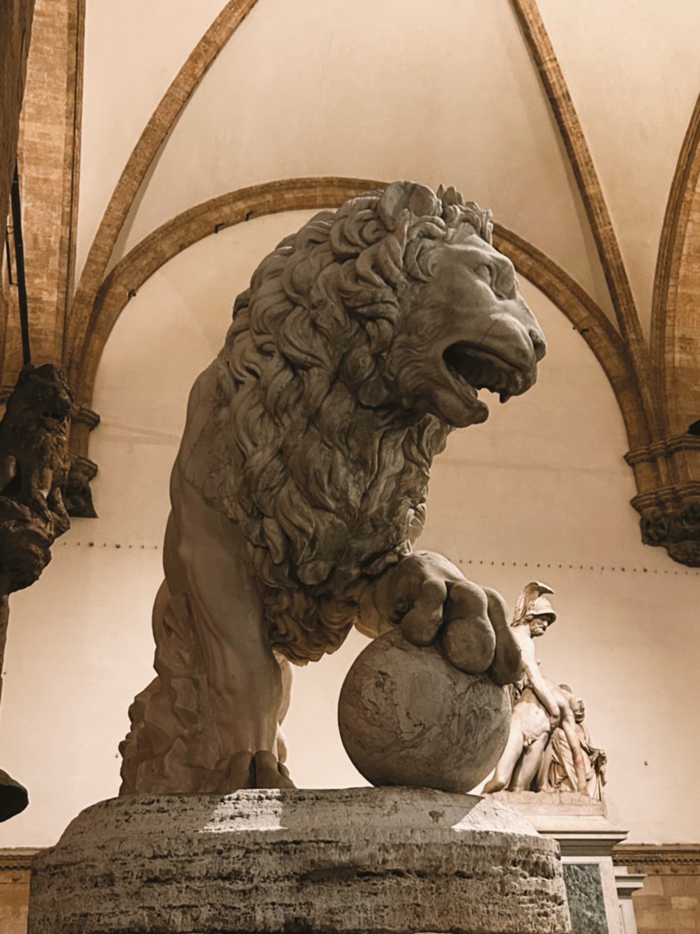 a marble lion beneath a vaulted loggia