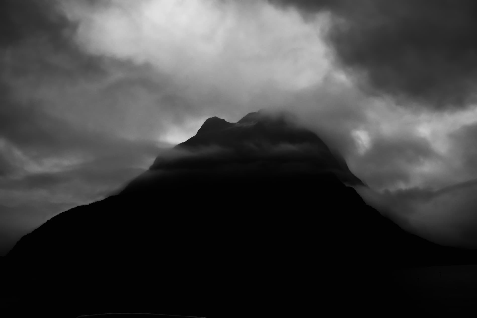 A silhouetted peak surrounded by thick cloud