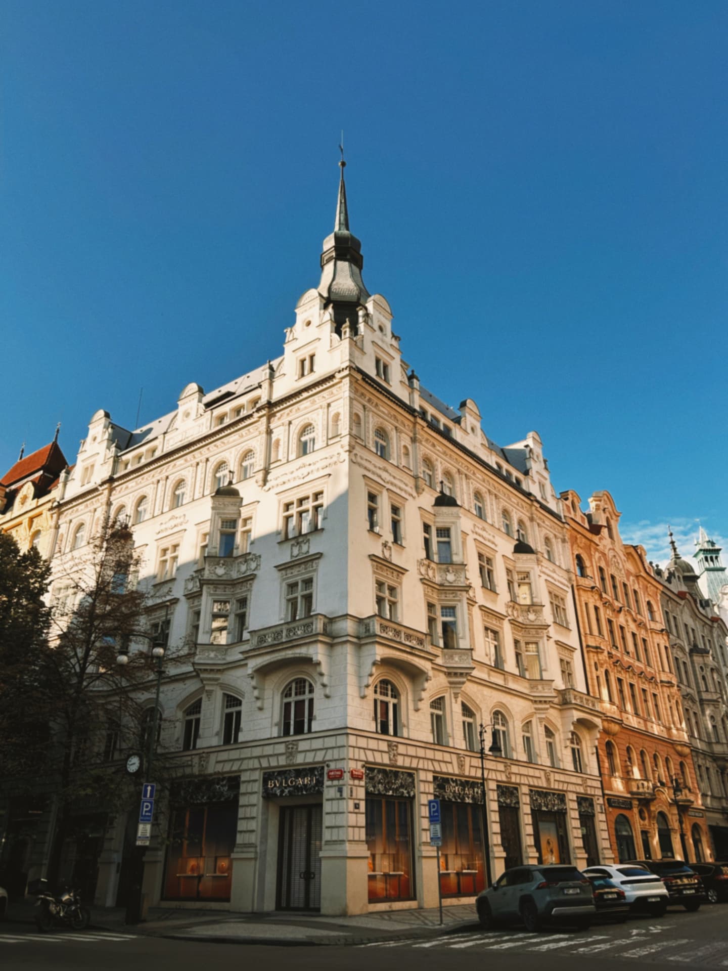 an ornate pale corner building on a city street