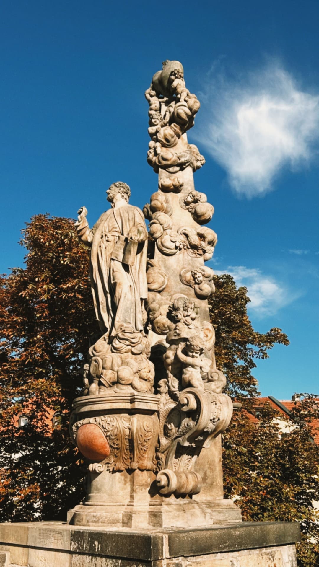 a baroque stone statue against a blue sky