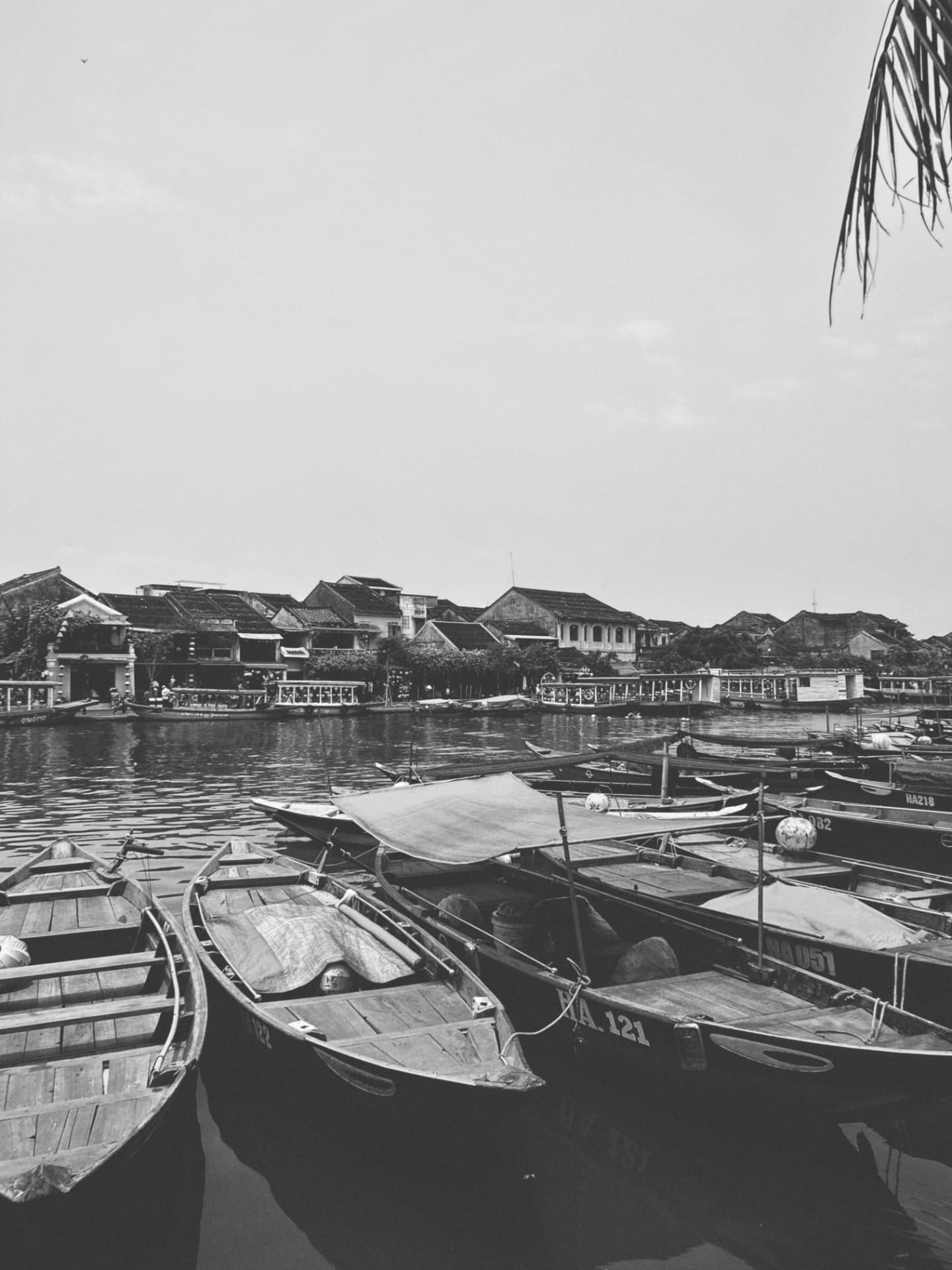 Wooden boats moored in front of an old riverfront town