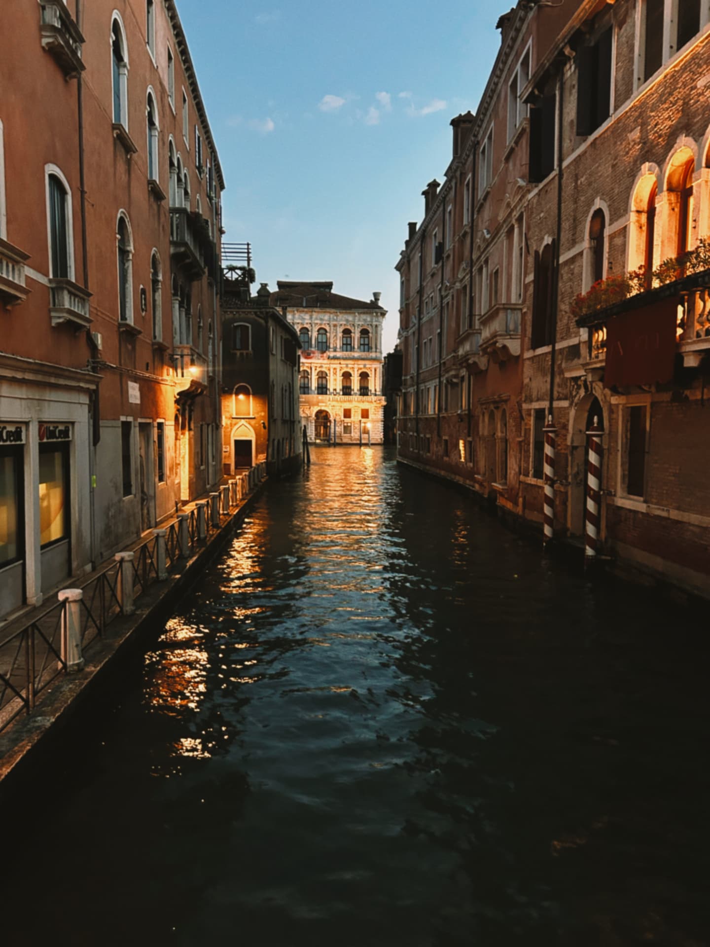 quiet canal at dusk under warm lamplight