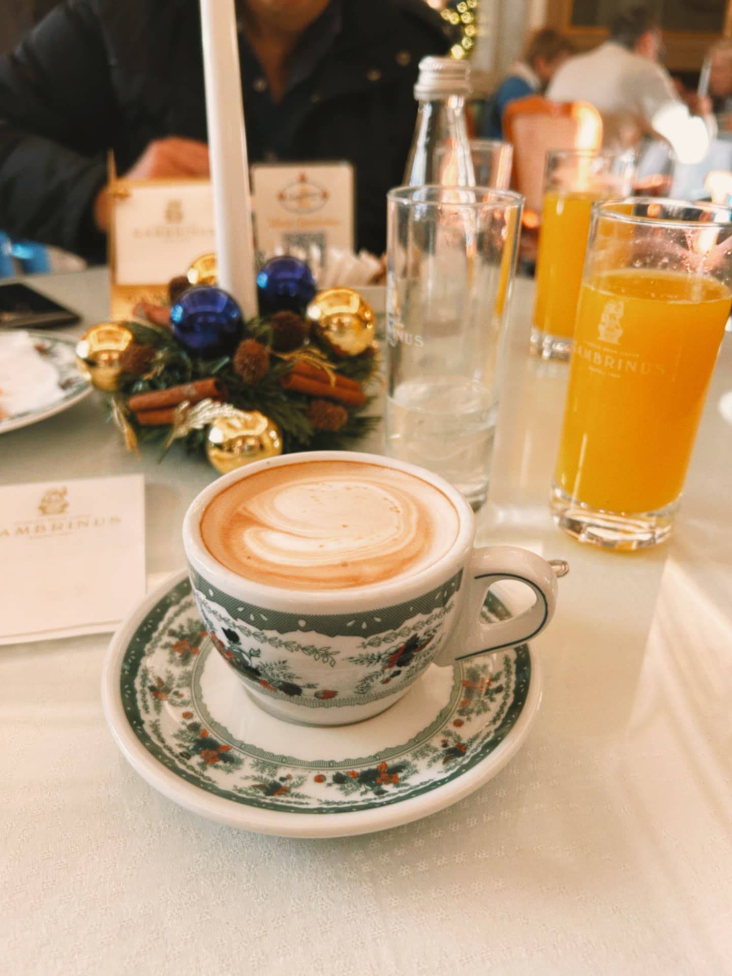 a cappuccino cup on a painted saucer at a cafe table