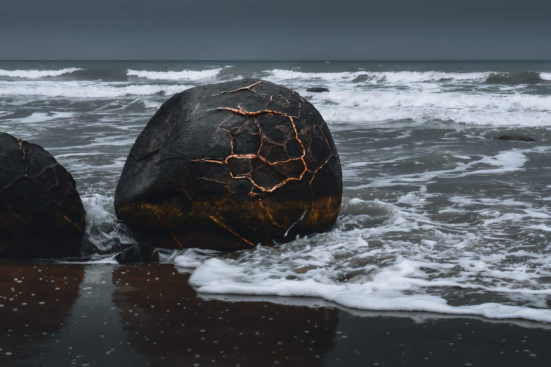 A round boulder in the surf traced with golden seams