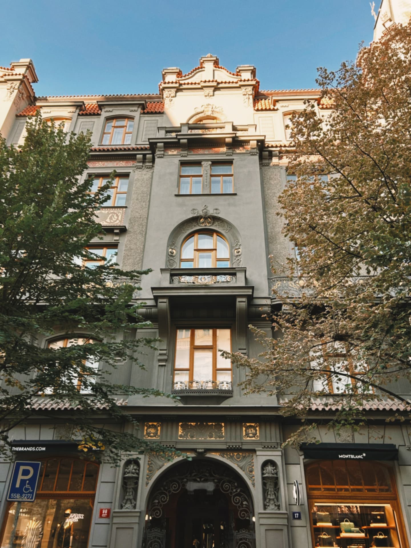 a grey art nouveau facade with golden ornament