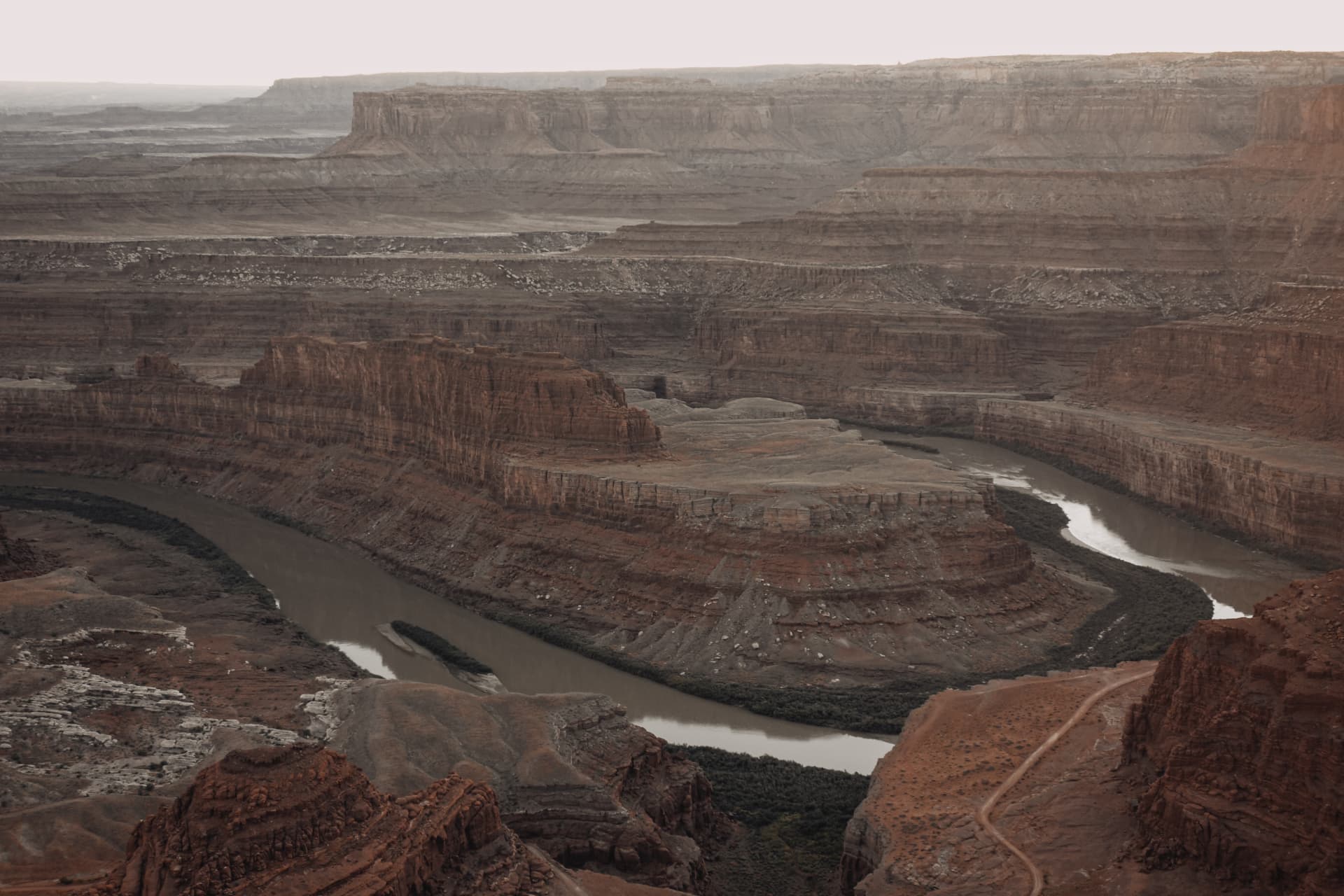 A canyon carrying a winding river between layered cliffs