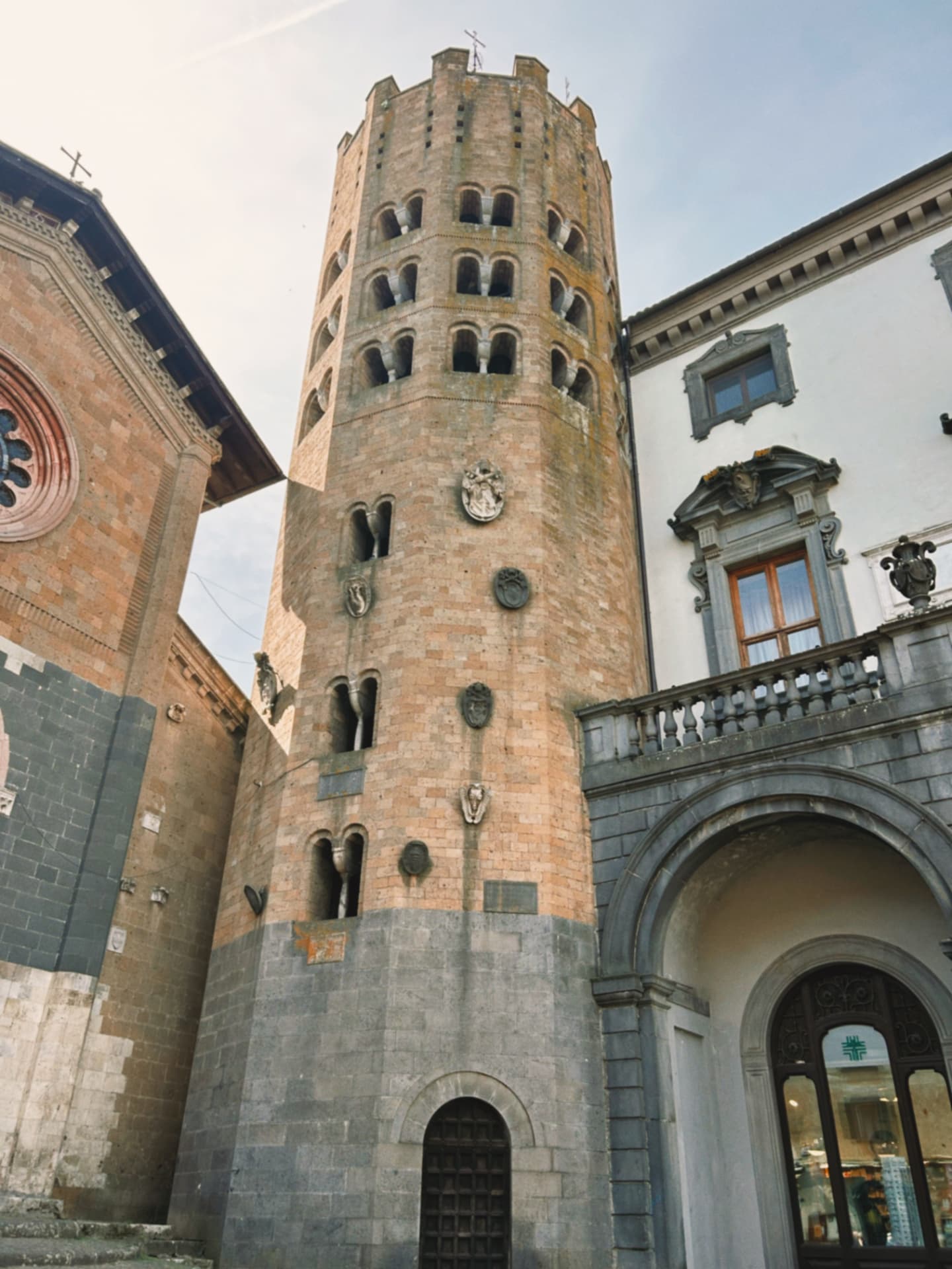 a round stone bell tower between historic buildings