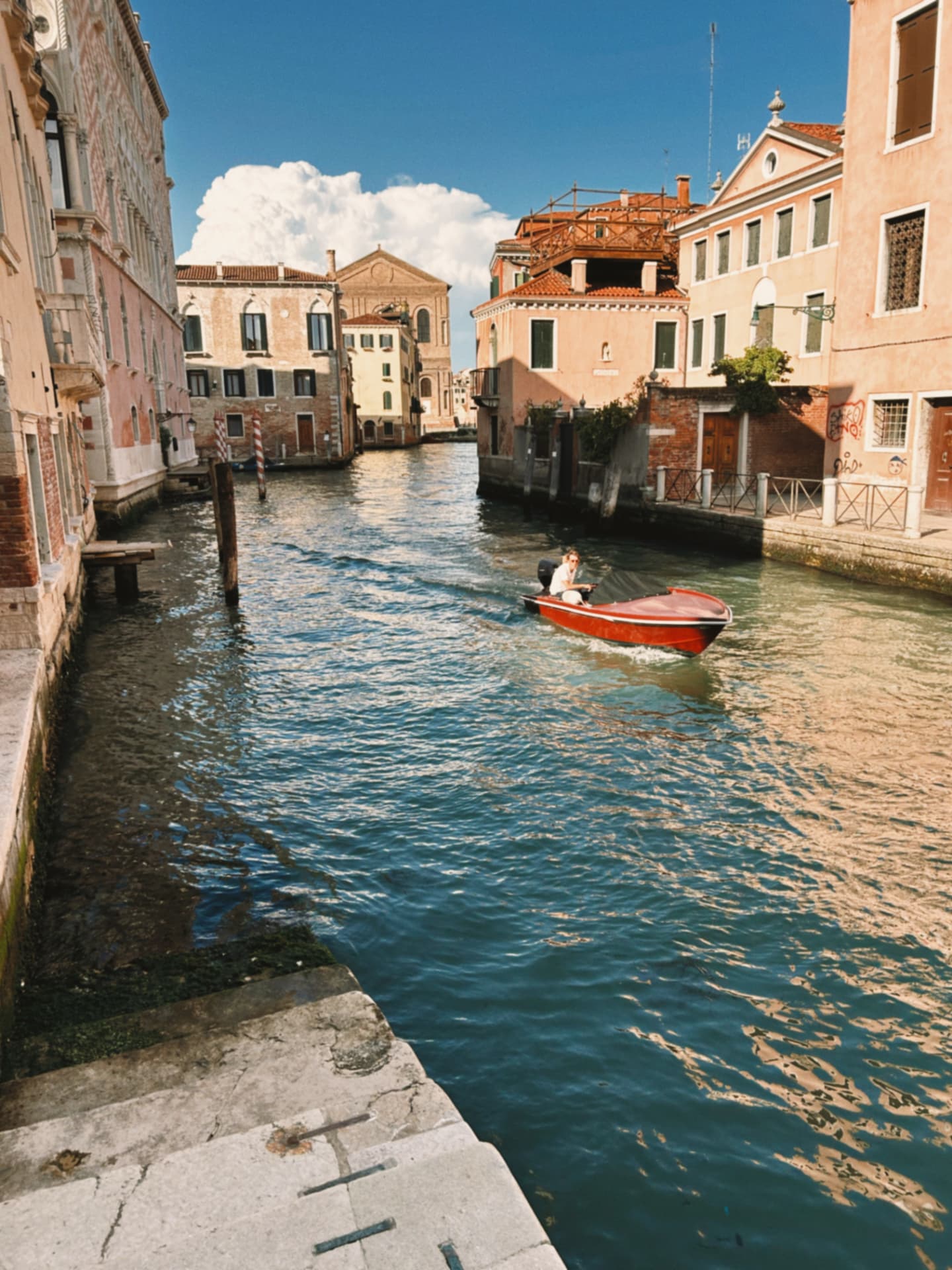 Venice canal with a moored red boat