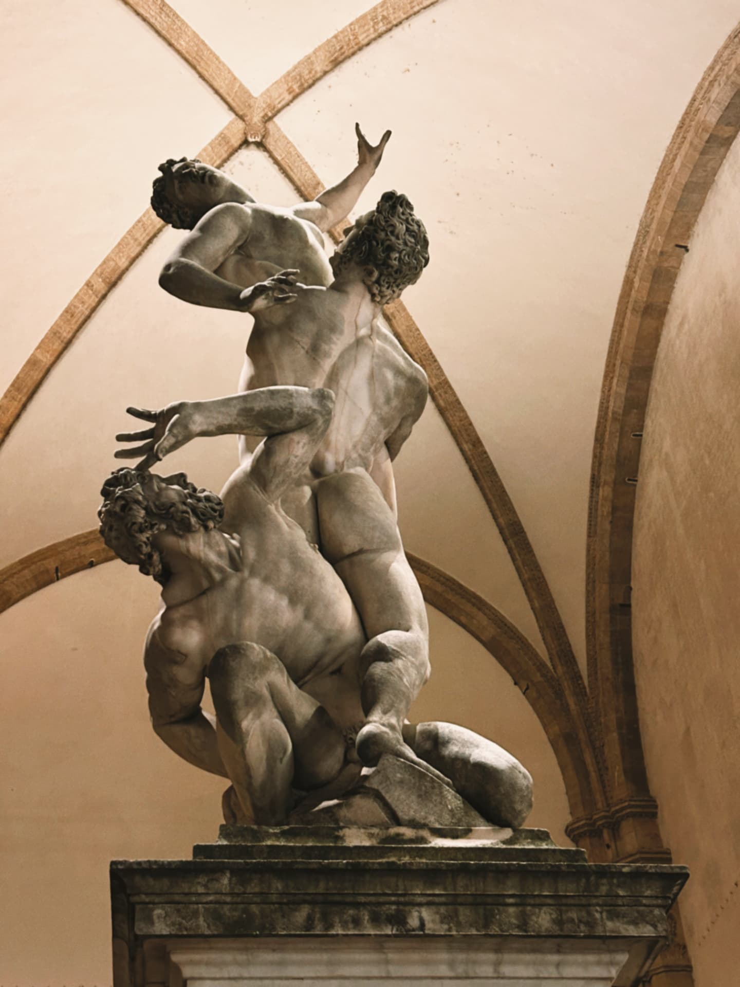 a marble sculpture group under an arched ceiling