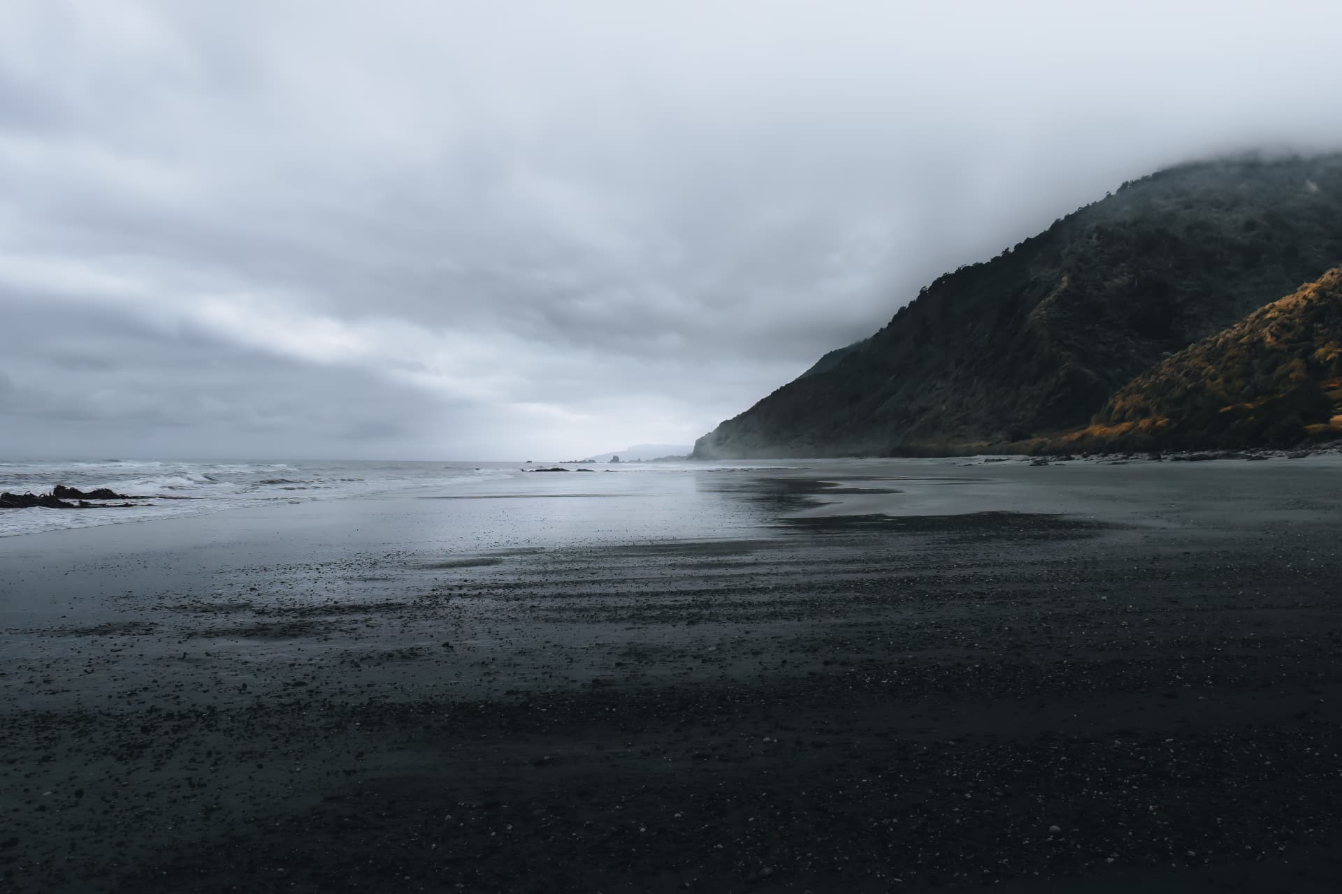 A stormy coast with cloud-wrapped cliffs touched by golden light